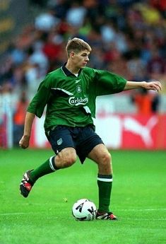 a young man kicking a soccer ball on a field