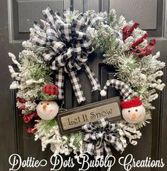 a wreath with two snowmen on it and a sign that says dotie dot's bubbly creations