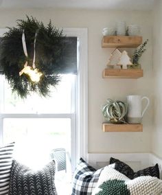 a window sill filled with pillows and wreaths