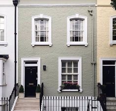 a row of houses with white windows and black doors