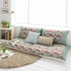 a living room filled with lots of furniture next to a book shelf and window sill