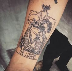 a person with a tattoo on their arm that says the lover and two skeletons holding hearts