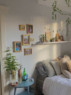 a bedroom with white walls and lots of pictures on the wall