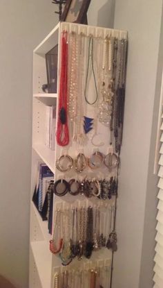 a white shelf filled with lots of bracelets and rings on it's sides