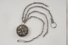 a silver chain with a small round pendant on it's end and a key hanging from the front