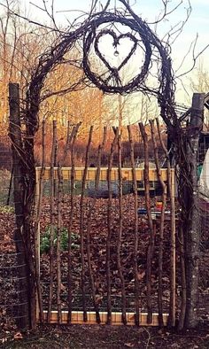 a heart shaped trellis in the middle of a garden