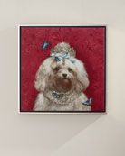 a white dog with blue butterflies on it's head sitting in front of a red background