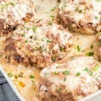 meat patties covered in gravy and garnished with parmesan cheese