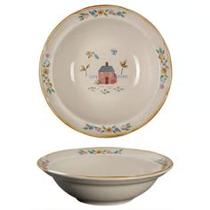 an empty bowl sitting on top of a white plate with a house painted on it