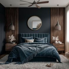 a bedroom with dark blue walls and white rugs, a round mirror above the bed