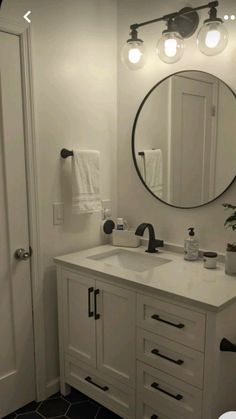 a bathroom with a sink, mirror and lights