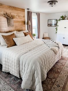 a bedroom with a large bed and wooden headboard on top of a carpeted floor