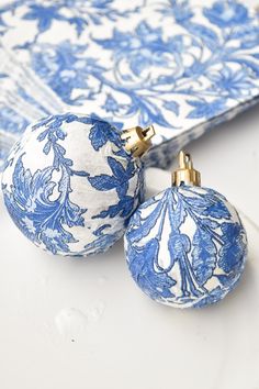 two blue and white ornaments sitting on top of a table