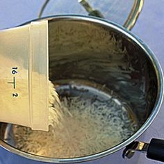 a metal bowl filled with rice on top of a stove