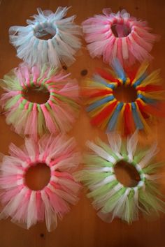 four different colored tulle hair ties on a wooden table with holes in the middle