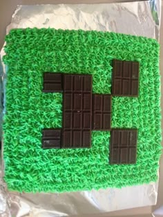 a cake made to look like an 8 - bit chocolate block on top of green grass