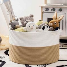 a basket filled with stuffed animals sitting on top of a white rug next to a stove