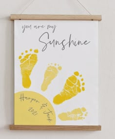 a hand and foot print hanging on a wall next to a sign that says you are my sunshine