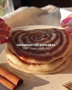 cinnamon roll pancakes are stacked on top of each other with cinnamon sticks next to them