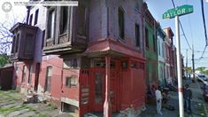 an old red building with people standing outside