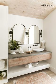 a bathroom with two sinks and mirrors on the wall