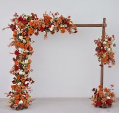 an orange and white wedding arch decorated with flowers