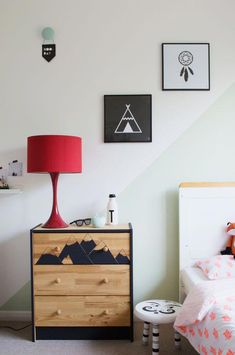 a child's bedroom with a dresser, bed and pictures on the wall above it