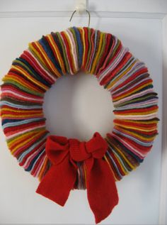 an image of a colorful wreath hanging on the wall with a red bow attached to it