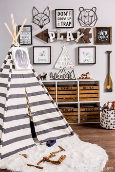 a teepee tent sitting in front of a wall filled with pictures and other items