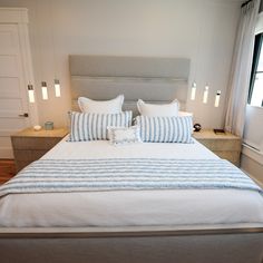 a bed with white and blue pillows in a bedroom