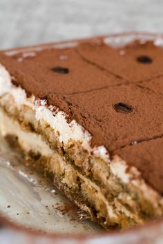 a piece of cake on a plate with chocolate chips and white frosting in the middle