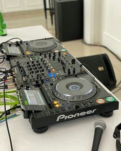 a dj controller sitting on top of a table next to a microphone and headphones