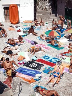 many people are laying on the beach towels