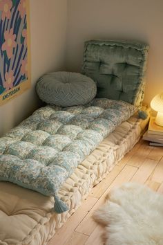 an unmade bed in a small room with a rug on the floor next to it