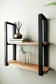 two wooden shelves with vases and candles on them in front of a white wall