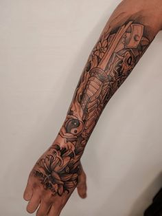 a man's arm with tattoos on it and his hand in the air,