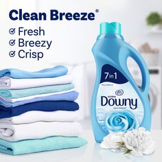 a bottle of downy dishwasher deterant next to folded towels and flowers