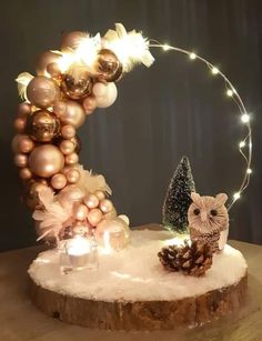 an owl figurine sitting on top of a wooden table next to christmas decorations