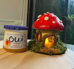 a jar of peanut butter sitting next to a mushroom house on top of a table