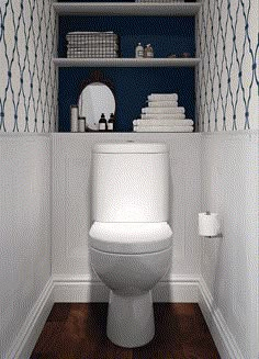 a white toilet sitting inside of a bathroom next to a shelf filled with folded towels