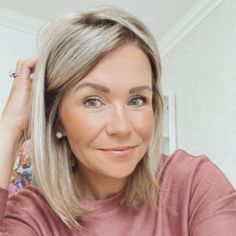 a woman with blonde hair is looking at the camera while she has her hand on her head