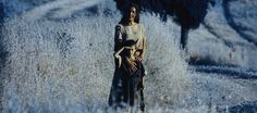 a woman standing in the middle of a field