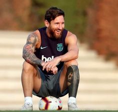 a man sitting on top of a soccer ball