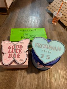 two decorated cookies sitting on top of a wooden table