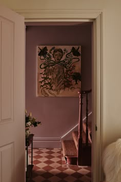 an entry way with a painting on the wall and stairs leading up to another room