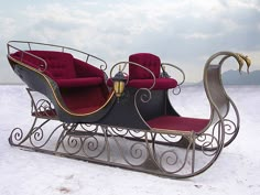 a horse drawn carriage in the snow with two seats on it's back and wheels