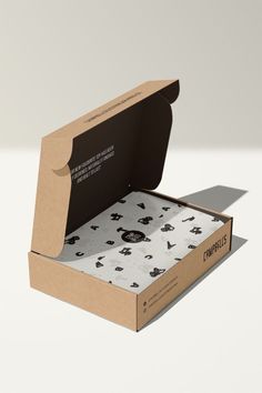 an open cardboard box with black and white designs on the inside that says compostles