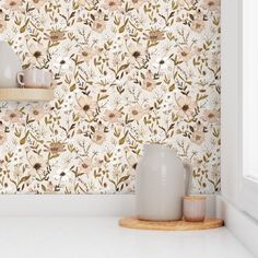 a white vase sitting on top of a counter next to a wallpapered wall