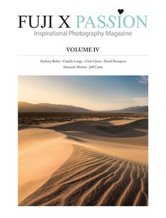 an image of the cover of a magazine with sand dunes in the background and mountains in the distance