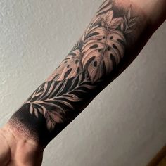 a person's arm with a black and white tattoo design on the left forearm